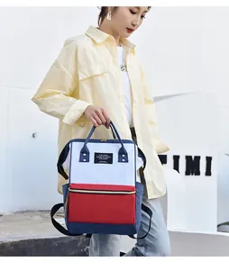 Close-up of a stylish tricolor waterproof oxford diaper backpack being held by an Asian model