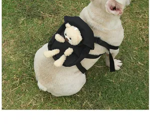 Detail shot of a black pet dog backpack featuring a cute plush bear on a French Bulldog.