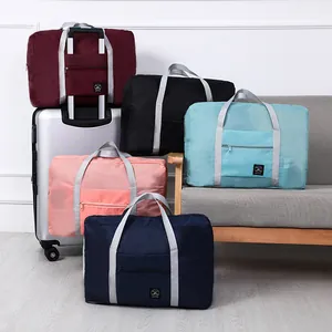 Multi-colored waterproof foldable travel storage bags displayed on a sofa and suitcase