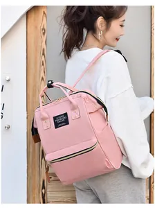 Large pink waterproof Oxford cloth mummy backpack shown on a female model for commuting