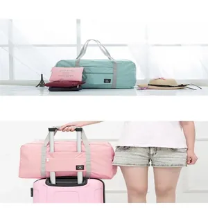 Large foldable travel bag shown mounted on a suitcase handle for easy transport