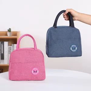 Portable insulated lunch bags in pink and blue colors shown in a bright lifestyle setting.