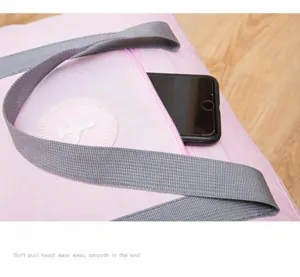 Detail view of pink waterproof travel bag featuring a widened handle and a front zipper pocket.