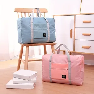 Large capacity waterproof folding travel storage bags in blue and pink lifestyle view