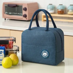 Insulated lunch bag with top handle and bear patch in navy blue fabric