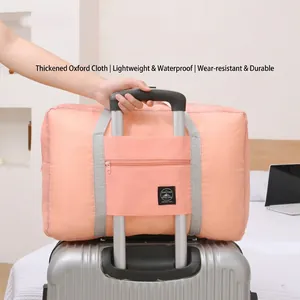 Large capacity pink foldable waterproof oxford travel bag attached to a silver suitcase