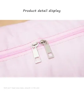 Detail of durable alloy dual zippers on a light pink waterproof travel bag.
