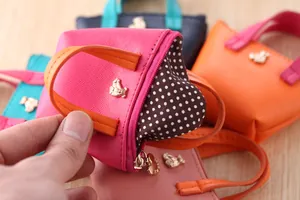 Détail de la mini pochette en cuir avec doublure à pois et fermeture à glissière.