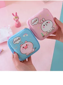 Pair of cute cartoon sanitary napkin storage bags in pink and blue held by hand.
