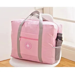 Hochwertige große rosa faltbare Reisetasche mit Flugzeug-Logo auf einem weißen Stuhl