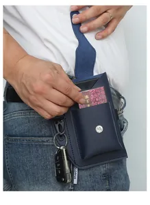 Détail d'une sacoche de ceinture en cuir bleu avec pochette téléphone et porte-clés porté.
