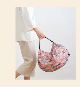 Modelo con una gran bolsa de lona plegable para la compra con estampado de camuflaje rosa