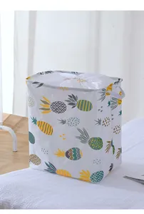 Vue détaillée d'un grand panier à linge pliable orné d'un imprimé ananas très coloré