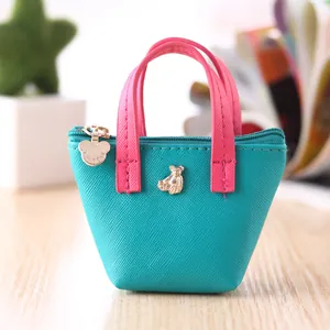 Vue détaillée du mini porte-monnaie turquoise avec poignées roses et breloque ours