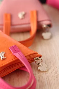 Détail rapproché de la fermeture à glissière ours sur un mini porte-monnaie en cuir