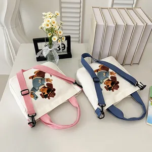 Close-up of cute dachshund dog embroidery on two stylish white canvas crossbody bags