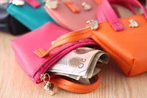 Gros plan d'un mini porte-monnaie couleur bonbon avec billets pliés