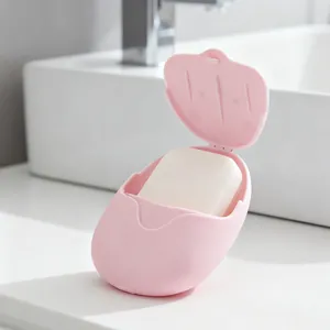 Jabonera de viaje rosa portátil con mini jabón sobre lavabo blanco