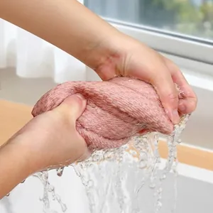 Highly absorbent pink corn kernel texture kitchen cleaning cloth being wrung out.