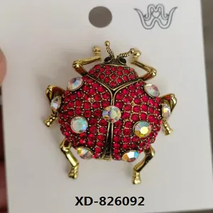 Macro detail of a vintage beetle brooch with red rhinestones on a gold alloy base
