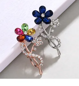 Detailed close-up showing vibrant crystal petals and sparkling rhinestones on flower brooches