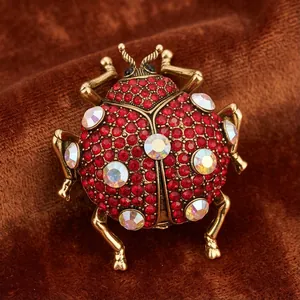 Vintage red rhinestone ladybug beetle brooch pin with antique gold finish for suits