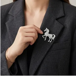 Elegante zilveren met strass ingelegde paardvormige broche op een grijze blazerrevers