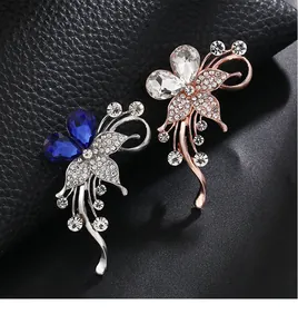 Macro detail shot of elegant crystal butterfly brooches in blue and rose gold finishes