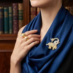 Elegant golden elephant brooch with crystals and matching hammered ring on a model.