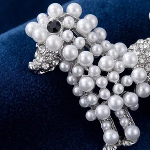Élégante broche caniche ornée de perles blanches et strass sur fond en velours bleu roi