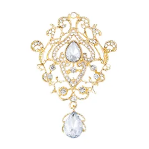 Ornate vintage Baroque gold-tone brooch featuring sparkling crystals and a teardrop pendant
