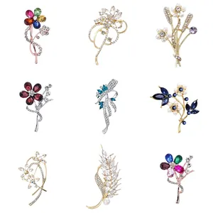 Elegant set of nine crystal flower brooches with various rhinestone and pearl designs.