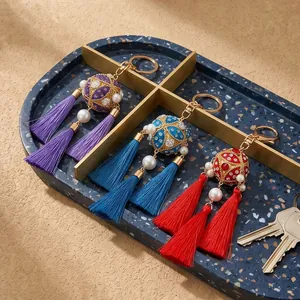 Detailed view of handmade Chinese style embroidered ball tassel keychains in three colors