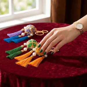 Detailed view of traditional handmade embroidered ball tassel keychains on elegant red velvet