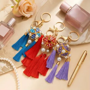 Close-up detail of handmade ethnic tassel keychains with colorful crystals and pearls.