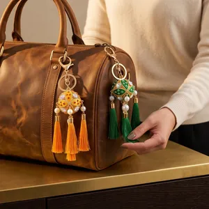 Close-up of colorful handcrafted hydrangea tassel charms on a brown leather bag.