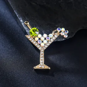 Primer plano de un broche de copa de martini con gema verde y cristales brillantes