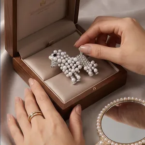 Broche caniche élégante avec perles et strass dans un coffret à bijoux haut de gamme