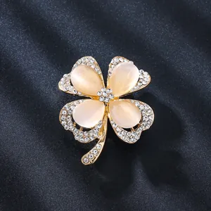 Close-up of an elegant four-leaf clover brooch with cat-eye stones and rhinestones