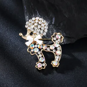 Détail d'une broche caniche scintillante avec un nœud blanc et des cristaux colorés