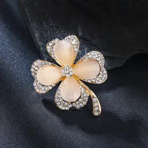 Elegant four-leaf clover brooch featuring creamy cat's eye stones and sparkling rhinestones