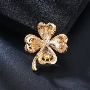 Back view of a luxury gold four-leaf clover brooch with textured finish and secure pin