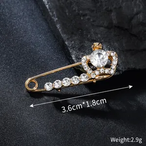 Detailed view of an elegant gold crown brooch pin with rhinestones, size 3.6x1.8cm