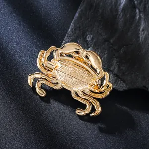 Detailansicht der Rückseite einer goldfarbenen Krabbenbrosche mit sicherem Anstecknadel.