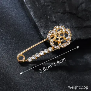 Detailed view of a gold-toned flower brooch pin with sparkling rhinestones and dimensions.