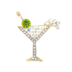Elegante broche de copa de cóctel con diamantes de imitación y detalle de oliva verde.