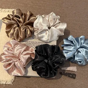 Detailweergave van kleurrijke parelmoer satijnen scrunchies met fonkelende strass.