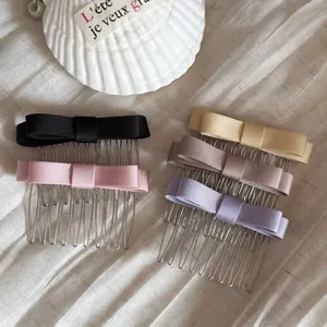Five elegant satin bow hair combs in assorted colors like pink, black and lavender.