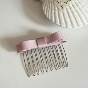 Elegant pink satin bow hair comb clip for creative hair styling and fashion accessories.