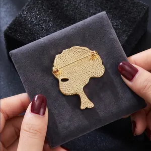 Elegant gold carnation alloy brooch pin shown from its back view on grey velvet cushion.